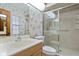 Full bathroom with a single sink vanity, toilet, patterned wallpaper and glass enclosed tiled shower at 360 Pineview St, Altamonte Springs, FL 32701