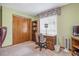 Carpeted bedroom features a wooden desk, bookcase, large closet, and light green painted walls at 360 Pineview St, Altamonte Springs, FL 32701