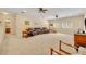Spacious living room area with plush carpeting, ceiling fans, and a leather sofa at 369 Torgiano Dr, Ocoee, FL 34761