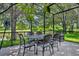 Shaded, screened-in patio with outdoor dining set overlooking a serene backyard pond at 369 Torgiano Dr, Ocoee, FL 34761