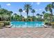 Large community swimming pool surrounded by tropical landscaping and shaded seating areas at 369 Torgiano Dr, Ocoee, FL 34761