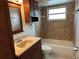 Cozy bathroom with wooden cabinets, tiled shower/tub, and neutral decor, offering a functional design at 3739 S Fern Creek Ave, Orlando, FL 32806