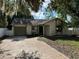 Charming single-story home featuring a brick driveway and well-maintained landscaping, set beneath mature trees at 3739 S Fern Creek Ave, Orlando, FL 32806