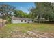 Large backyard featuring a well-maintained lawn and a building with a neutral color scheme at 384 Zinnia Dr, Casselberry, FL 32707