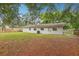 Spacious backyard with mature trees offering shade and the back of a building with AC unit at 384 Zinnia Dr, Casselberry, FL 32707