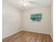 Bright bedroom with wood floors, a ceiling fan, and a window overlooking the yard at 384 Zinnia Dr, Casselberry, FL 32707