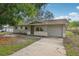 View of the single-story home with gray exterior, driveway, and small front yard at 384 Zinnia Dr, Casselberry, FL 32707