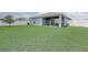 Exterior view of backyard with covered patio and white fence at 392 Citrine Loop, Kissimmee, FL 34758