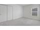 Bright bedroom features neutral carpet, a window, and a double-door closet at 392 Citrine Loop, Kissimmee, FL 34758