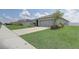 Street view of a well-maintained home featuring a two-car garage and landscaped front yard at 392 Citrine Loop, Kissimmee, FL 34758