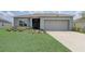 Charming single-story home featuring a well-manicured lawn and a two-car garage at 392 Citrine Loop, Kissimmee, FL 34758