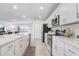 Bright kitchen with white cabinets, stainless steel appliances, and a view into the living room at 392 Citrine Loop, Kissimmee, FL 34758