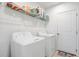 A bright laundry room with washer, dryer and storage shelf above at 392 Citrine Loop, Kissimmee, FL 34758