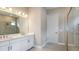 Bathroom featuring double sinks, quartz counters, tile flooring, and a glass enclosed shower at 4209 Barbuda Ln, Kissimmee, FL 34758