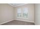 Neutral bedroom features wall-to-wall carpeting and two windows at 4209 Barbuda Ln, Kissimmee, FL 34758