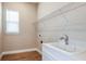 Bright laundry room features a window, sink, and a wire rack for organized storage at 4209 Barbuda Ln, Kissimmee, FL 34758