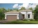 Beautiful single-story home featuring a two-car garage, well-manicured lawn, and classic architectural details at 4215 Barbuda Ln, Kissimmee, FL 34758