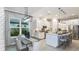Open concept kitchen with stainless appliances, island seating, and adjacent dining area with stylish lighting at 4215 Barbuda Ln, Kissimmee, FL 34758