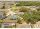 An aerial view of a single Gathering home in a residential neighborhood with green trees and maintained lawns at 508 Churchill Pl, Poinciana, FL 34759