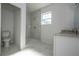 Bright bathroom featuring marble tile shower, granite vanity, and ceramic toilet at 508 Churchill Pl, Poinciana, FL 34759