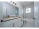 This bathroom features dual sinks, a marble-look shower, and white cabinetry at 508 Churchill Pl, Poinciana, FL 34759
