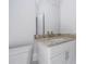 This bathroom shows a granite vanity and sink with white cabinetry, plus a large mirror at 508 Churchill Pl, Poinciana, FL 34759