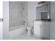 A bright bathroom features marble-style tile on the walls and floor, a tub, and a vanity at 508 Churchill Pl, Poinciana, FL 34759