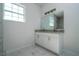 Bathroom with double vanity, granite countertop, and a large mirror at 508 Churchill Pl, Poinciana, FL 34759
