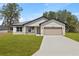 Charming single-story home featuring a two-car garage, well-manicured lawn, and neutral-toned exterior at 508 Churchill Pl, Poinciana, FL 34759