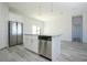 Bright kitchen boasts stainless steel appliances, gray wood floors, and white cabinets and countertops at 508 Churchill Pl, Poinciana, FL 34759