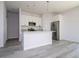 Kitchen with gray wood floors, white cabinets, granite countertops and stainless steel appliances at 508 Churchill Pl, Poinciana, FL 34759