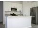 Bright kitchen with white cabinets, granite countertops, stainless appliances, and gray wood floors at 508 Churchill Pl, Poinciana, FL 34759