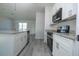 Open kitchen area with stainless steel appliances, granite countertops, and gray wood floors at 508 Churchill Pl, Poinciana, FL 34759