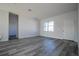 A well-lit living room features gray wood floors, white walls, and a large front window at 508 Churchill Pl, Poinciana, FL 34759