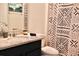 A well-lit bathroom featuring dark cabinets, granite countertops and shower with geometric design at 5273 Oakbourne Ave, Davenport, FL 33837