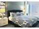 Comfortable bedroom with stylish decor, featuring a queen-size bed, hardwood floors, and bedside tables at 5273 Oakbourne Ave, Davenport, FL 33837