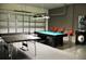 Game room with ping pong and pool table, accented by a brick wall, overhead lighting, and a garage door at 5273 Oakbourne Ave, Davenport, FL 33837