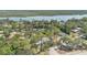 Picturesque aerial shot showcases the home surrounded by mature trees and waterfront views at 5505 W Magnolia Ave, Port Orange, FL 32127