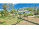 Inviting backyard featuring lush green lawn, mature trees, and well-maintained landscaping at 5505 W Magnolia Ave, Port Orange, FL 32127
