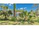 Landscaped front yard with mature palms and shrubs, showcasing the home's curb appeal at 5505 W Magnolia Ave, Port Orange, FL 32127