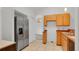Bright kitchen featuring stainless steel refrigerator and wood cabinets on tile floor at 5505 W Magnolia Ave, Port Orange, FL 32127