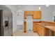 Bright kitchen featuring wood cabinets, stainless steel refrigerator, and tile floors at 5505 W Magnolia Ave, Port Orange, FL 32127