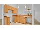 Functional kitchen area with wooden cabinets, double sink, and easy access to the living room, awaiting your personal touch at 5505 W Magnolia Ave, Port Orange, FL 32127