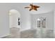 Spacious living room with light tile flooring, arched doorways and access to the backyard through glass doors at 5505 W Magnolia Ave, Port Orange, FL 32127