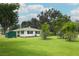 Well-manicured, green lawn and ranch house with shed under cloudy sky at 656 Lake Charm Dr, Oviedo, FL 32765
