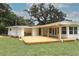 Charming home featuring a backyard with wooden deck, lush lawn, and mature trees at 656 Lake Charm Dr, Oviedo, FL 32765