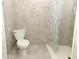 Tiled bathroom featuring a toilet and shower with neutral colors and simple fixtures at 656 Lake Charm Dr, Oviedo, FL 32765