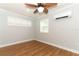 Cozy bedroom featuring wood floors, shuttered windows, ceiling fan, and an air conditioning unit at 656 Lake Charm Dr, Oviedo, FL 32765