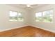Bright bedroom features gleaming hardwood floors and two large windows offering pleasant outdoor views at 656 Lake Charm Dr, Oviedo, FL 32765