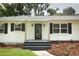 Inviting front entrance features black door with glass detail, flanked by sconces and manicured landscaping at 656 Lake Charm Dr, Oviedo, FL 32765